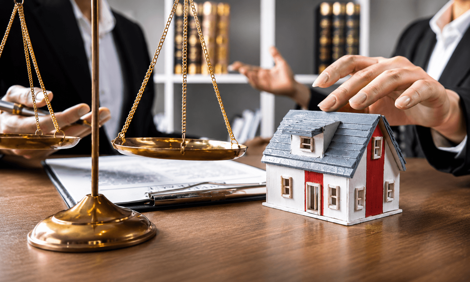 Scales of justice beside a small model house on a desk, representing legal protection for property investment in Türkiye.